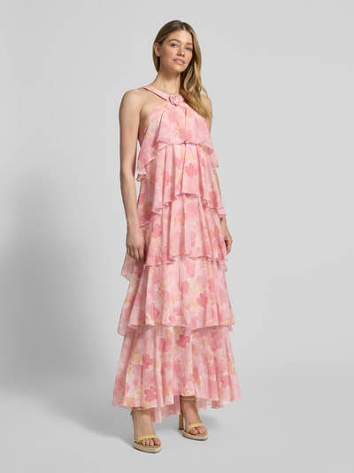 Frauenmodel trägt Volant Abendkleid mit V-Ausschnitt Modell 'FELICIA' von Vero Moda in Rosa mit Blumenmuster aus Chiffon, Ganzkörperansicht von vorne.