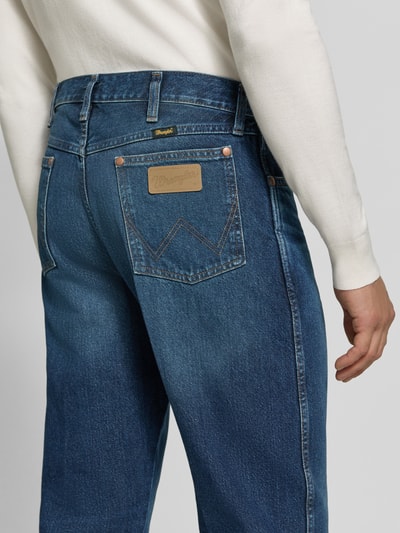 Mężczyzna nosi Straight Fit Jeans aus reiner Baumwolle Modell '13MWZ Cowboy' von Wrangler, ciemnoniebieski denim z przeszyciami i metką, Ganzkörperansicht Rückansicht, Herren Straight Fit Jeans von Wrangler