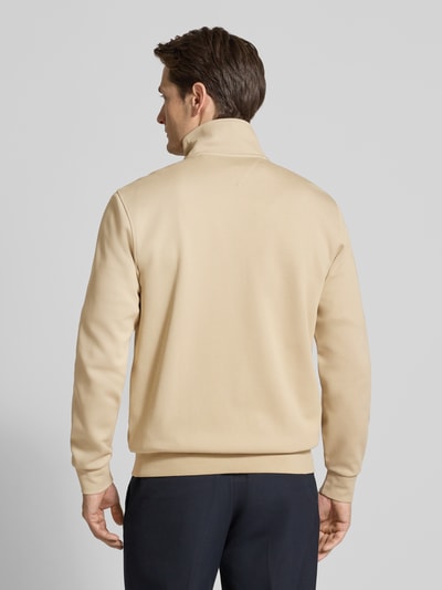 Männermodel trägt Regular Fit Blouson aus Baumwoll-Mix von Tommy Hilfiger in Beige, unifarben, elastische Abschlüsse, Ganzkörperansicht Rückansicht.