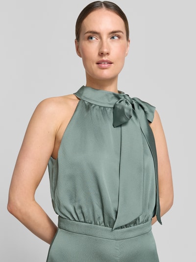 Modelka kobieca nosi Jumpsuit mit Schluppe und rückseitigem Knopfverschluss von Swing, satyna, krój slim fit, z wiązaną kokardą na szyi, szerokość w rozmiarze 36: 66 cm, długość całkowita: 152 cm, tylny zamek i guzik, miękka, lekko błyszcząca faktura, zielony kolor, zbliżenie górnej części ciała