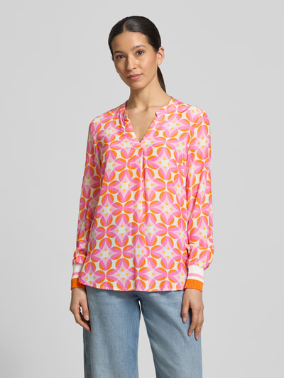Modelka kobieca nosi Regular Fit Bluse aus reiner Viskose od Emily Van den Bergh, różowo-pomarańczowy geometryczny nadruk, długie rękawy, tunikowy dekolt, elastyczne mankiety, widok całej sylwetki z przodu