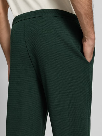 Männermodel trägt Regular Fit Sweathose aus Baumwoll-Mix von BOSS in dunklem Grün mit feiner Struktur, Nahaufnahme Rückansicht, Herren Sweathose von BOSS