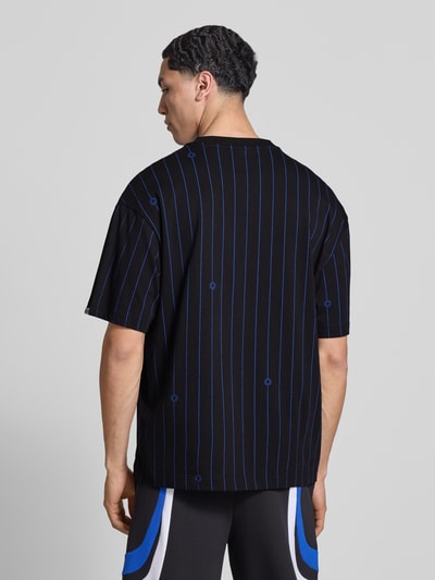 Mannelijk model draagt Regular Fit T-Shirt uit puur katoen model 'NORAYATI' van Hugo Blue met allover gestreept patroon, smiley labelprint, ronde hals, korte mouw, jersey structuur; zwarte en blauwe kleuren, materiaal katoen. Volledige lichaamsopname achterkant.