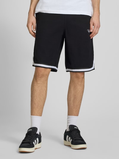 Männermodel trägt Shorts mit Logo-Stitching Modell 'Signar' von Pegador aus Reine Baumwolle mit Kontraststreifen, Gerader-Schnitt, Bundweite 40 cm, Innenbeinlänge 27 cm, Ganzkörperansicht von vorne.