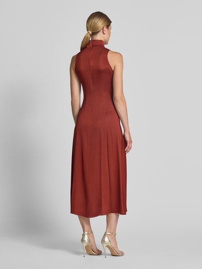 Frauenmodel trägt Maxikleid mit Stehkragen und Drapierungen Modell 'AMABEL' von DRYKORN, rostrote Farbe, A-Linie, Rückansicht Ganzkörperansicht.