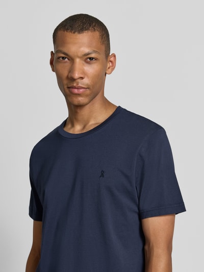 Männermodel trägt dunkelblaues Regular Fit T-Shirt aus reiner Baumwolle Modell 'JAAMES' von ARMEDANGELS, Nahaufnahme Oberkörper.