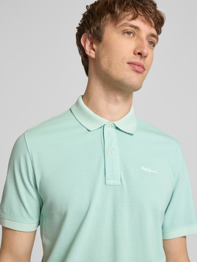Männermodel trägt Regular Fit Poloshirt aus reiner Baumwolle Modell 'OSCAR' von Pepe Jeans, Optik: Unifarben, Nahaufnahme Oberkörper.
