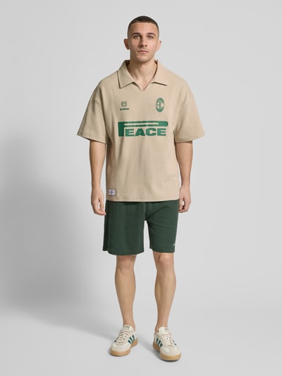 Männermodel trägt Regular Fit Poloshirt mit Logo-Detail von ANOTHER COTTON LAB aus Baumwoll-Mix mit Strukturmuster, Polokragen, Ganzkörperansicht von vorne.