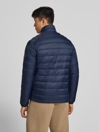 Męski model nosi Regular Fit kurtka w z efektem pikowania Model 'Kingsley' od JACK & JONES, kolor granatowy, widok całej sylwetki z tyłu. Długość tyłu w rozmiarze M: 72 cm, szerokość ramion w rozmiarze M: 48 cm, szerokość klatki piersiowej w rozmiarze M: 51 cm, długość rękawów w rozmiarze M: 68 cm, stójka, zamek błyskawiczny, wpuszczane kieszenie.