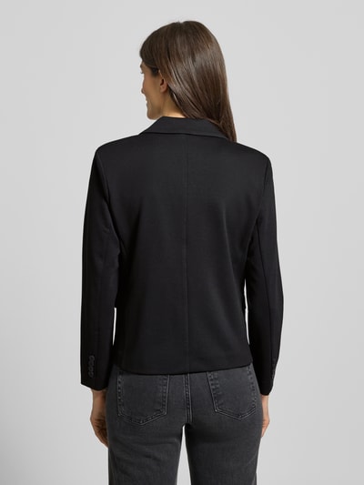 Kobiece modelka nosi Regular Fit Blazer mit Viskose-Anteil Modell 'Nanni' od FREE/QUENT, czarny, tekstura gładka, pełny tył, krój regular fit, elastischer materiał z wiskozą, długość tyłu 61 cm w rozmiarze S, szerokość w rozmiarze S 50 cm, długość rękawa 56 cm, widok całej sylwetki z tyłu.