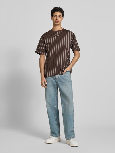 Männermodel trägt Regular Fit T-Shirt mit Logo-Stitching von KARL KANI, braun mit weißen Streifen, Reine Baumwolle, Rundhalsausschnitt, Rückenlänge bei Größe M 85 cm, Herren T-Shirt, Ganzkörperansicht von vorne.