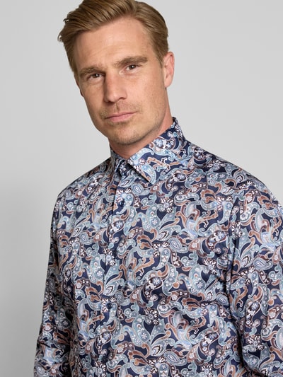 Męski model nosi Modern Fit Businesshemd aus reiner Baumwolle od OLYMP, kolorowy wzór paisley, gładka faktura, zbliżenie na górną część ciała, koszule biznesowe.