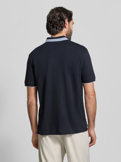 Mężczyznamodel nosi Regular Fit Poloshirt aus reiner Baumwolle mit Stehkragen von Christian Berg Men, ciemnoniebieska, stójka, krótkie rękawy, elastyczne zakończenia, długość tyłu w rozmiarze M: 75 cm, widok całej sylwetki z tyłu.