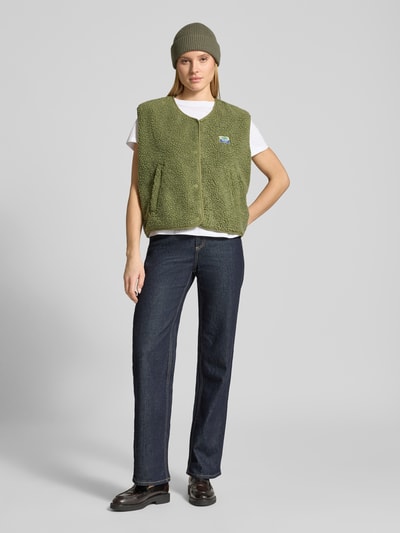 Vrouwenmodel draagt Bodywarmer met ronde hals Model 'HOKTOWN' van American Vintage in groen teddybont met steekzakken, labeldetail, drukknoopsluiting, los model, volledig zichtbaar van voren
