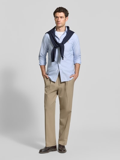 Męski model nosi Regular Fit Freizeithemd aus reiner Baumwolle von Polo Ralph Lauren, jasnoniebieskie paski, widok całej sylwetki z przodu.