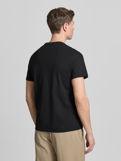 Männermodel trägt T-Shirt mit Rundhalsausschnitt und Logo von CK Calvin Klein, reine Baumwolle, Regular Fit, Rückenlänge 70 cm, Ganzkörperansicht Rückansicht.