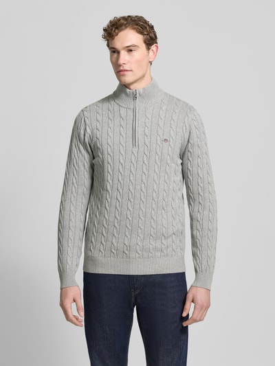 Männermodel trägt Strickpullover mit gerippten Abschlüssen von Gant in Grau, reine Baumwolle, Slim-Fit, Stehkragen, Label-Stitching, Ganzkörperansicht von vorne.