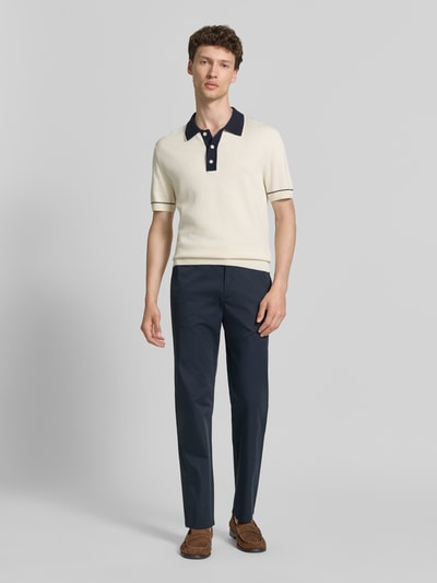 Männermodel trägt Chino mit Eingrifftaschen von Christian Berg Men in Dunkelblau, glatte Textur, Regular Fit, Ganzkörperansicht von vorne.