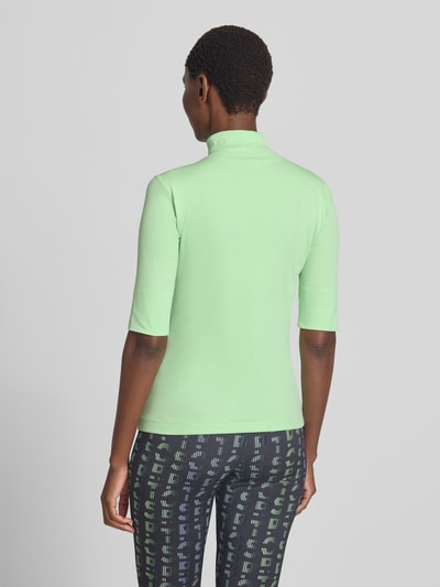 Frauenmodel trägt Slim Fit T-Shirt aus Baumwoll-Mix mit Stehkragen von Marc Cain, pastellgrün, Rückenlänge 54 cm, Ganzkörperansicht Rückansicht.