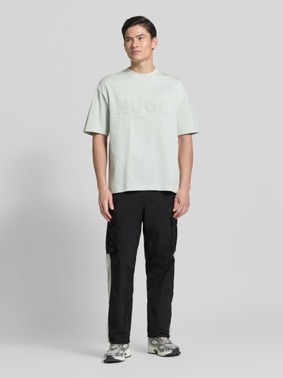 Männermodel trägt Regular Fit Cargohose mit Label-Applikation Modell 'COLAS262' von HUGO in Two-Tone-Optik, Twill, Ganzkörperansicht von vorne