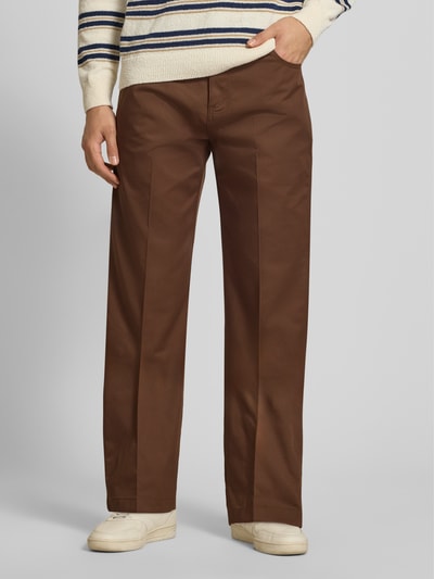 Männermodel trägt Loose Straight Fit Hose mit Bügelfalten von Dickies, brauner Material-Mix, Eingrifftaschen, Nahaufnahme Oberkörper.