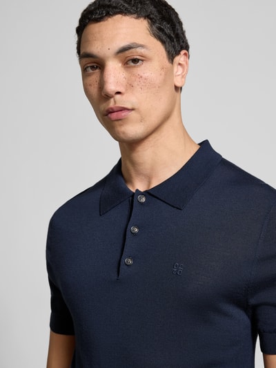 Männermodel trägt Slim Fit Poloshirt in Strick-Optik von Dsquared2 aus reiner Baumwolle mit Polo-Kragen und Logo-Stitching, Nahaufnahme Oberkörper.
