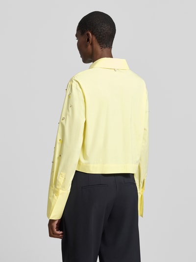 Vrouwenmodel draagt Relaxed Fit Hemdbluse met Allover-Ziersteinbesatz van Liu Jo White in lichtgeel katoenmix met lange mouwen, overhemdkraag, knoopsluiting en sportmanchet, ruglengte maat 36 48 cm, mouwlengte 61 cm, Ganzkörperansicht Rückansicht.