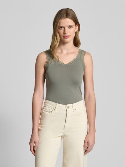 Frauenmodel trägt Slim Fit Tank Top aus Viskose-Mix Modell 'BARBERA LACE' von Pieces in Unifarbe mit Spitzenbesatz, Ganzkörperansicht von vorne.