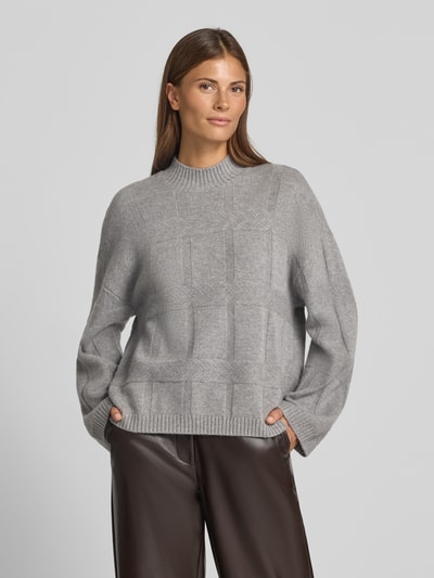 Frauenmodel trägt Oversized Wollpullover mit Kaschmir-Anteil von Emporio Armani in Grau mit Strukturmuster, Stehkragen, gerippten Abschlüssen, Nahaufnahme Oberkörper.