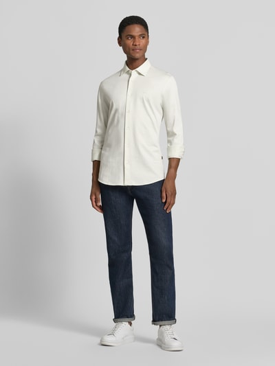 Männermodel trägt Slim Fit Freizeithemd aus reiner Baumwolle Modell 'MYSOFT_2' von BOSS, BOSS Orange, helles Beige, Ganzkörperansicht von vorne.
