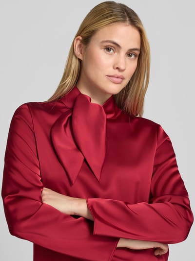 Frauenmodel trägt Regular Fit Bluse aus Satin von Emporio Armani in kräftigem Rot, Stehkragen, langärmelig, Nahaufnahme Oberkörper.