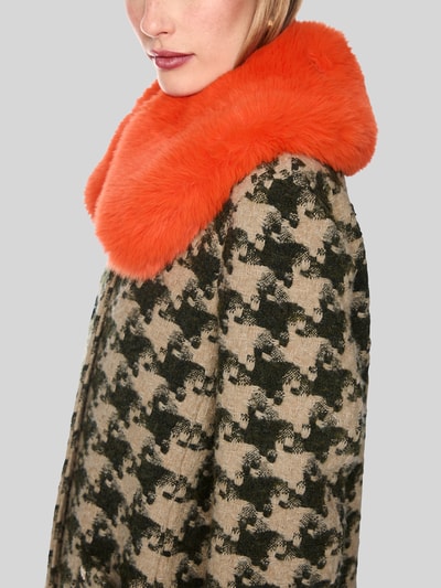 Frauenmodel trägt Mantel mit Kragen aus Kunstfell von Marc Cain in Beige mit schwarzem Muster, kräftig orangener Kragen, Nahaufnahme Oberkörper, Material-Mix mit Woll-Anteil, Regular Fit, Allover-Look, Knopfverschluss, aufgesetzte Taschen.