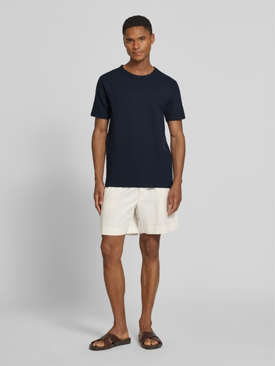 Männermodel trägt Regular Fit T-Shirt aus Baumwoll-Mix Modell 'SANDER' von SELECTED HOMME in Unifarben, Seersucker-Struktur, Ganzkörperansicht von vorne.