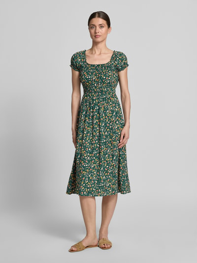 Kobiece modelka nosi Midikleid aus Viskose mit Smok-Details von Apricot, zielony materiał w kwiaty, okrągły dekolt z falbankami, rękawy z falbankami, krój taliowany, długość z tyłu w rozmiarze S: 105 cm, szerokość w rozmiarze S: 40 cm, widok całej sylwetki z przodu.