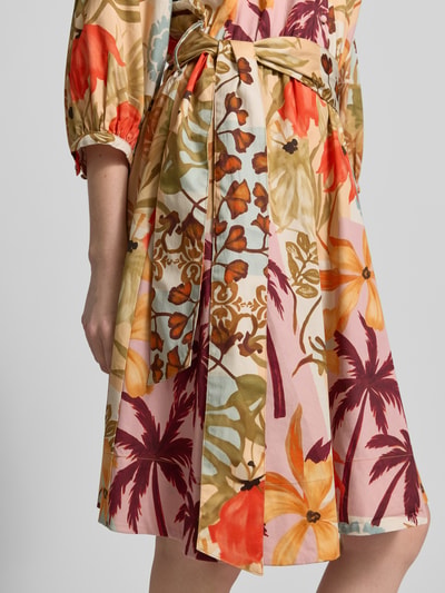 Vrouwenmodel draagt Knielanges Hemdblusenkleid im Allover-Look met Bindegürtel van Christian Berg Woman, puur katoen, a-lijn, knielengte, all-over look, strikceintuur, ruglengte maat 36: 100 cm, borstwijdte maat 36: 56 cm, mouwlengte maat 36: 42 cm, kleurrijk bloemen- en bladerenpatroon, detailopname heup.