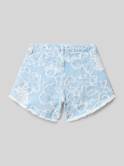 Mädchen trägt Jeansshorts mit Fransensaum und Label-Detail von Guess, hellblau mit weißem floralen Muster, Reine Baumwolle, Straight Fit, 5-Pocket-Design, Knopf-Reißverschluss, Bundweite 32 cm, Innenbeinlänge 9 cm, Ganzkörperansicht Rückansicht.
