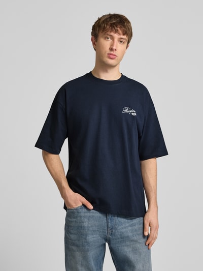 Männermodel trägt T-Shirt mit Rundhalsausschnitt und Label-Print von REVIEW in Dunkelblau, Relaxed-Fit aus Reiner Baumwolle, Herren T-Shirt, Ganzkörperansicht von vorne. Rückenlänge bei Größe M: 71 cm.