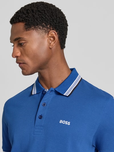 Männermodel trägt Regular Fit Poloshirt mit Label-Stitching Modell 'Paddy' von BOSS, reine Baumwolle, Blau, Nahaufnahme Oberkörper.