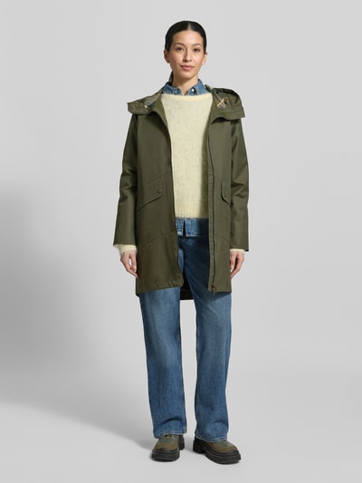 Kobiece model prezentuje Regular Fit Parka aus Baumwoll-Mix od Barbour, jednokolorowy, z kapturem, krój regular fit, zamek błyskawiczny dwustronny, z napisem z logo, pas na plecach, długi rękaw, zakończenie proste, hydrofobowy, oddychający materiał, wpuszczane kieszenie boczne, kieszenie z patką, kieszeń wewnętrzna, mieszanka bawełny; widok całej sylwetki z przodu.