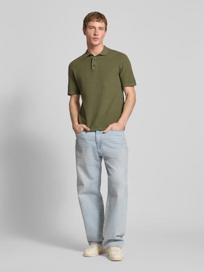 Męski model nosi Regular Fit Poloshirt mit Strukturmuster Modell 'GEORGE' od Jack & Jones, mieszanka bawełny, krój regular fit, zielony kolor, teksturowany materiał, zapięcie na guziki, długość tyłu w rozmiarze M: 67 cm, pełny widok z przodu
