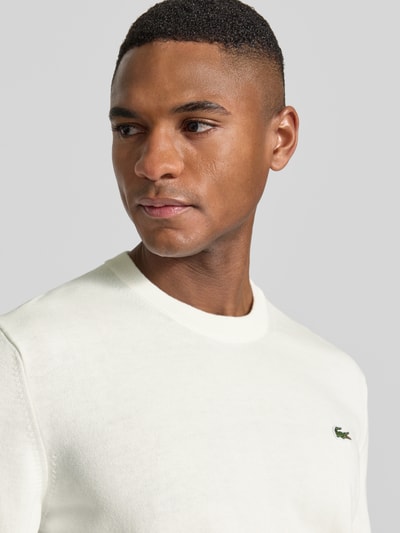 Männermodel trägt Regular Fit Strickpullover aus Baumwoll-Mix von Lacoste, Optik: Unifarben, Logo-Stitching, Nahaufnahme Oberkörper
