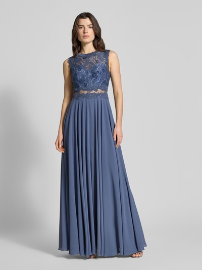 Kobiece modelka nosi Cocktailkleid mit floralem Spitzenbesatz von Mascara w niebieskim kolorze, taliowany krój, góra z haftem, halka pod spódnicę, wszyty zamek błyskawiczny, długość do ziemi, długość tyłu w rozmiarze 36: 152 cm, szerokość w rozmiarze 36: 36 cm, całopostaciowe ujęcie z przodu.