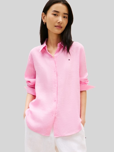 Vrouwenmodel draagt Relaxed Fit Langarmbluse aus reinem Leinen van Tommy Hilfiger, effen kleuren, relaxed fit, overhemdkraag, applicatie met gestikt logo, sluiting (bovenstuk): knoopsluiting, mouwen: lange mouw met manchet, rompzoom: afgerond, materiaalverwerking: gevlamd garen, materiaal: linnen. Nahaufnahme oberlichaam.