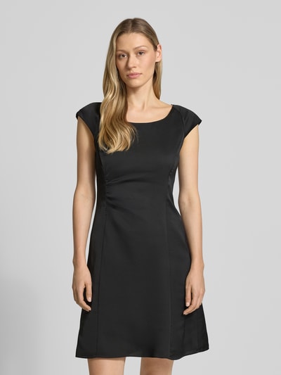 Frauenmodel trägt Knielanges Kleid mit Raffungen von ARMANI EXCHANGE in Schwarz, taillierter Schnitt, Rundhalsausschnitt, glatte Textur, Ganzkörperansicht von vorne. Rückenlänge 93 cm, Brustweite 42 cm bei Größe 36.