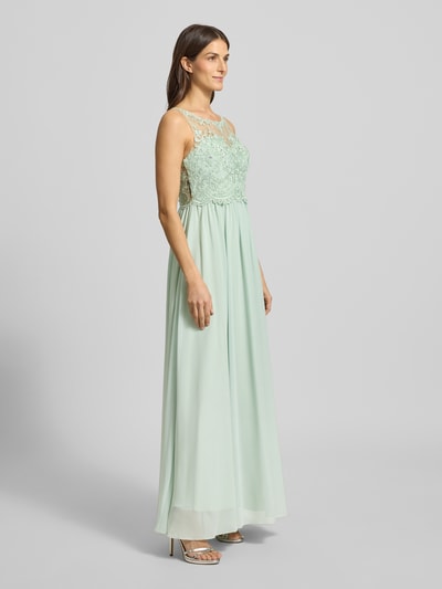 Frauenmodel trägt Regular Fit Abendkleid mit floralem Spitzenbesatz von Laona, semitransparentes Design in Mint mit Ziersteinbesatz, Ganzkörperansicht von vorne.