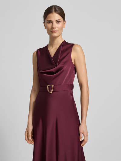 Kobiece model prezentuje Regular Fit Abendkleid aus Satin od Rinascimento w kolorze burgundowym, elastyczna mieszanka materiałów, lejący kołnierz, krój bez rękawów, odpinana materiałowa tasiemka, szerokość w rozmiarze S: 43 cm, długość tyłu: 123 cm, satynowa powierzchnia, półzbliżenie przód