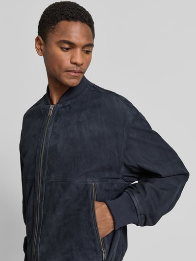 Mężczyzna model nosi Regular Fit Bomberjacke aus reinem Ziegenleder Modell 'JONORVE' od BOSS Orange, nubuk, ciemnogranatowa, zamek, długie rękawy, ribb, skóra, label, przód, zbliżenie na górną część ciała.