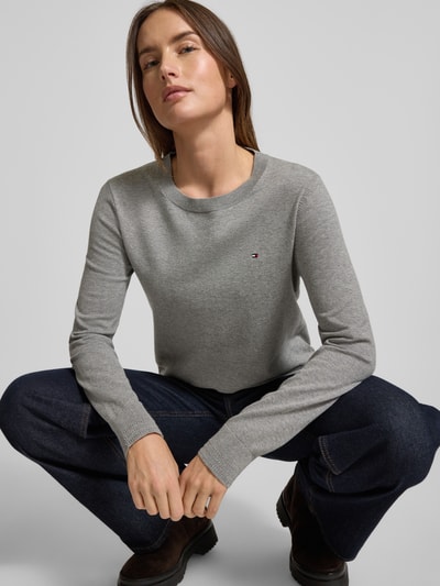 Vrouwenmodel draagt Regular Fit Strickpullover aus Baumwoll-Mix van Tommy Hilfiger, effen grijs, lange mouwen, ribstructuur, Nahaufnahme bovenlichaam.