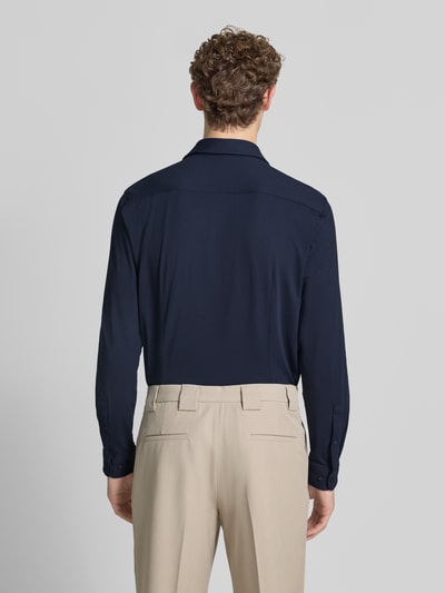 Männermodel trägt Slim Fit Business-Hemd mit Haifischkragen von Jake*s in Dunkelblau mit Strukturmuster, Material-Mix mit Stretch-Anteil, Rückenlänge bei Größe 39/40: 78 cm, Schulterbreite: 48 cm, Ärmellänge: 68 cm, Ganzkörperansicht Rückansicht.