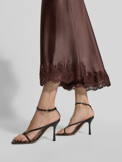 Vrouwenmodel draagt Midirok uit Satijn met kanten rand van Christian Berg Woman Selection, bruin, elastische materiaalmix, nauwsluitend, totale lengte maat 36: 90 cm, bandwijdte: 38 cm, detailopname onderbenen.